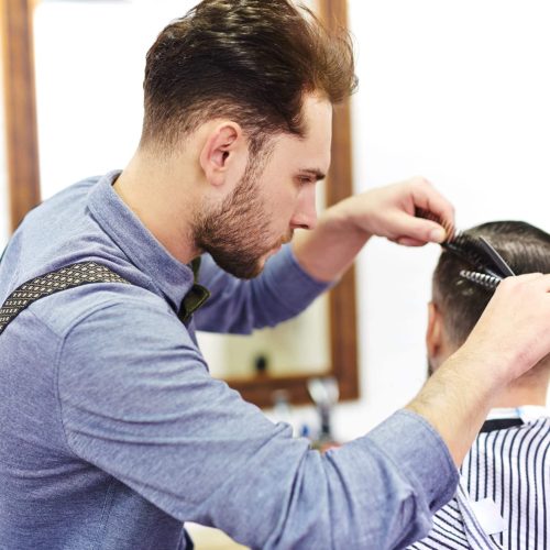 Modern hairdresser serving his client
